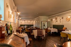 a restaurant with tables and chairs in a room at Locanda Gaudemus Boutique Hotel in Sistiana
