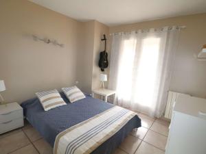 a bedroom with a bed with two pillows and a window at Villa 3 étoiles avec piscine privée, 500m de la plage, 4 chambres pour 6-8 pers. au Grau-du-Roi - FR-1-307-157 in Le Grau-du-Roi +16 photos