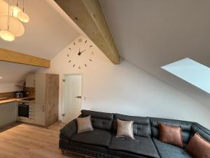 a living room with a couch and a clock on the wall at Fewo Elke in Marktoberdorf