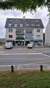 un grand bâtiment avec deux voitures garées devant lui dans l'établissement Superbe loft 90m² proche parc expo Nantes (6p), à Nantes