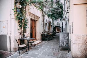 皮兰Second Life in Piran - Hotel Zala Piran with private parking and shuttle service的小巷里带桌椅的街道
