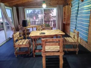 a dining room with a wooden table and chairs at Espace el aine in Harqalah