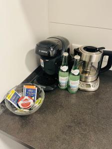a counter top with a coffee maker and two bottles at Sanssouci-FeWo 12 in Bad Kissingen