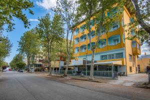 a yellow building on the side of a street at Hotel & Residence Parador in Cesenatico