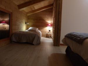 ein Schlafzimmer mit zwei Betten in einem Holzzimmer in der Unterkunft Gîte de Charme 10 Pers avec Cheminée et Parking - FR-1-467-100 in Le Grand-Bornand