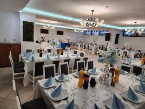 a banquet hall with white tables and chairs with blue napkins at Hotel Dunavis in Orşova
