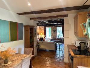 a kitchen with a table and a living room at Gites Boutique in Villamblard