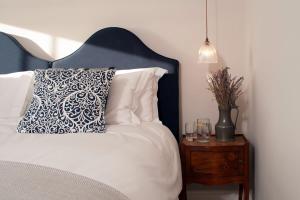 a bed with a blue headboard next to a nightstand with a pillow at Albion House at Ramsgate in Ramsgate