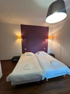 two beds in a room with a purple wall at Maison de ville idéale pour groupes et familles in Azay-le-Rideau +10 photos