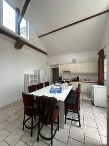 a kitchen with a large white table and chairs at Maison de ville idéale pour groupes et familles in Azay-le-Rideau