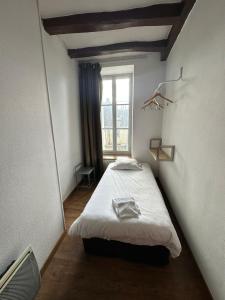 a small room with a bed with a window at Maison de ville idéale pour groupes et familles in Azay-le-Rideau