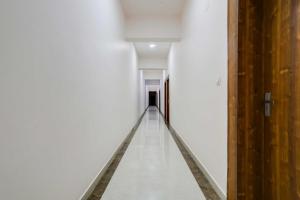 un long couloir avec des murs blancs et un long étage dans l'établissement Townhouse Oak Haldwani Kathgharia Chowk, à Haldwani