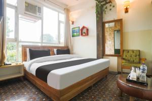 a bedroom with a large bed and a table at Hotel O Pacific Mall Rajpur Road in Dehradun +18 photos