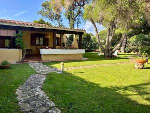a house with a stone walkway leading to a yard at Villa Giò Geremeas fronte mare in Marongiu