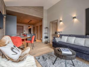 un soggiorno con un divano blu e un tavolo di Location 5 pers. à Courchevel - 2 pas des pistes, centre station, spa, parking inclus, WiFi, parking - FR-1-631-199 a Courchevel