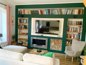 a living room with a green wall with a fire place at Marina Mikołajki in Mikołajki