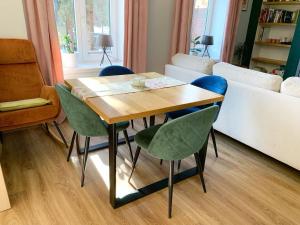 a table and chairs in a living room with a couch at Marina Mikołajki in Mikołajki
