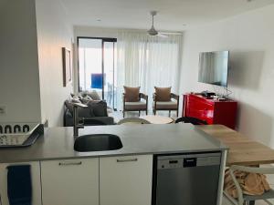 a living room with a kitchen and a living room with a couch at Eastern blue apartment seafront in Poste Lafayette