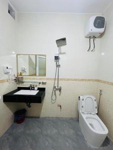 a bathroom with a toilet and a sink and a mirror at Peaceful Mountain Hotel in Ha Giang +17 photos