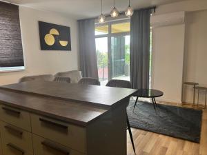 a kitchen with a island in a living room at Vibes-city apartman in Nyíregyháza +4 photos