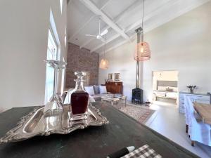 a living room with a table with a bottle of wine at Serendipity Guest Cottage in Prince Albert