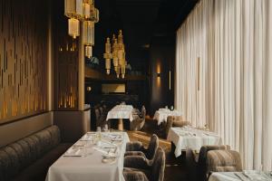 a dining room with two tables with white tablecloths at Hotel Blow Up Hall in Poznań