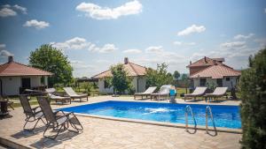 una piscina con sedie a sdraio e una piscina di Apartmani Čalane a Topola