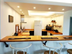 a kitchen with a table with chairs and a refrigerator at Maison du Troubadour in Balazuc