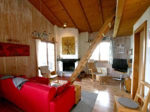 ein Wohnzimmer mit einem roten Sofa und einem Kamin in der Unterkunft Chalet Dalecarlia in Nendaz