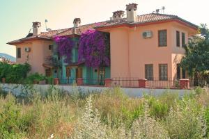 a house with purple flowers on the side of it at Villa Truva in Fethiye