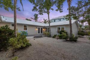 a white house with palm trees in front of it at Sunset Splash in Siesta Key