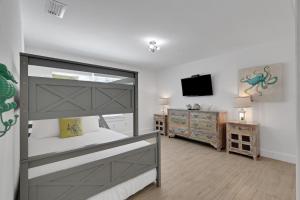 a bedroom with a large bed and a television at Sunset Splash in Siesta Key +48 photos