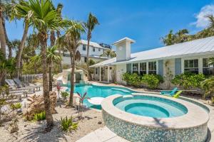 an exterior view of a house with a swimming pool and palm trees at Sunset Splash in Siesta Key