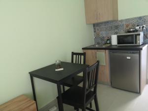 a small black table in a kitchen with a microwave at Isalos in Mérikhas