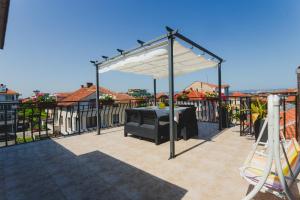 a pergola with a table on a patio at Guest House Ivy in Ravda