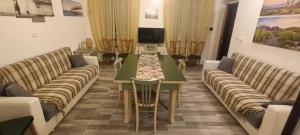 a living room with a long table and couches at A ca' vostra in Villanova dʼAsti