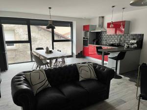 a living room with a leather couch and a table at Grange&Lodge in Chavelot