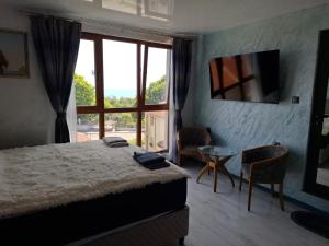 a bedroom with a bed and a table and a window at Magi Sunrise in Balchik