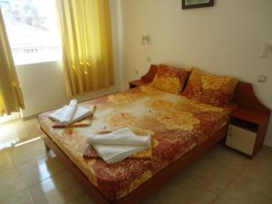 a bedroom with a bed with towels on it at Тихия кът in Sozopol +15 photos
