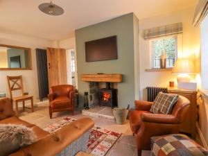 een woonkamer met een bank en een open haard bij Bridge House Cottage in Harrogate