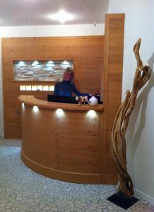 a woman sitting at a counter in a waiting room at Relais Fior di Bosco in Folgaria