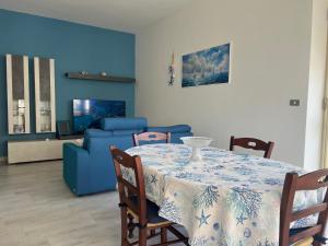 a dining room with a table and a blue couch at Ella Apartment in Otranto