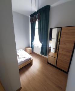 a bedroom with a mirror and a bed and a window at Apartament Willa Kilińskiego in Grudziądz