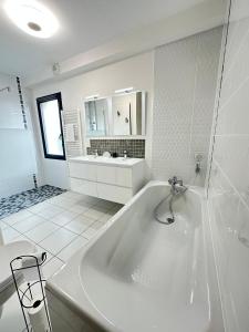 a white bathroom with a tub and a sink at La Bulle Familiale in Angoulême +19 photos