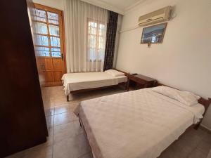 a hotel room with two beds and a window at Villa Truva in Fethiye