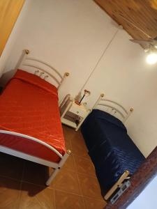 a bedroom with a bed with a red and blue mattress at Cabaña el gato blanco in La Porteña