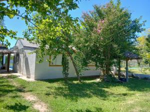 a white house with a tree in the yard at Cabaña el gato blanco in La Porteña