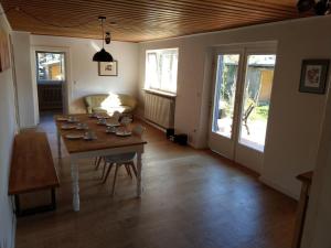 a dining room with a table with chairs and a room with at Haus Zwerchstum Übersee in Übersee