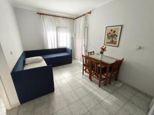 a living room with a blue couch and a table at Ioli Apartments in Limenas
