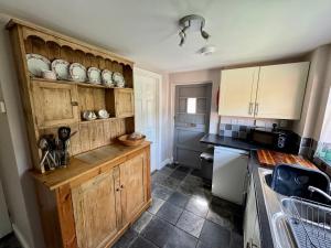 BoulstonにあるBryn Lodgeの木製のキャビネットとカウンタートップを備えたキッチン